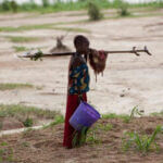 Girl returning from a day work on a large farm, Niger, West Africa. (Source: Mike Goldwater/Alamy Stock Photo)